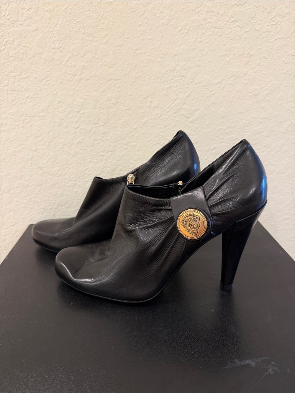 Gucci  NEVER WORN Black Leather High-Heel Ankle Booties - Gold Medallion Accent